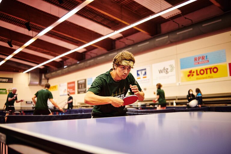 Mann trainiert an Tischtennisplatte