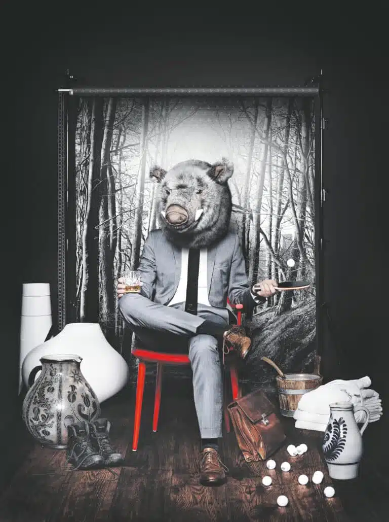 Mann mit Wildschweinkopf und Tischtennis-Schläger in der Hand