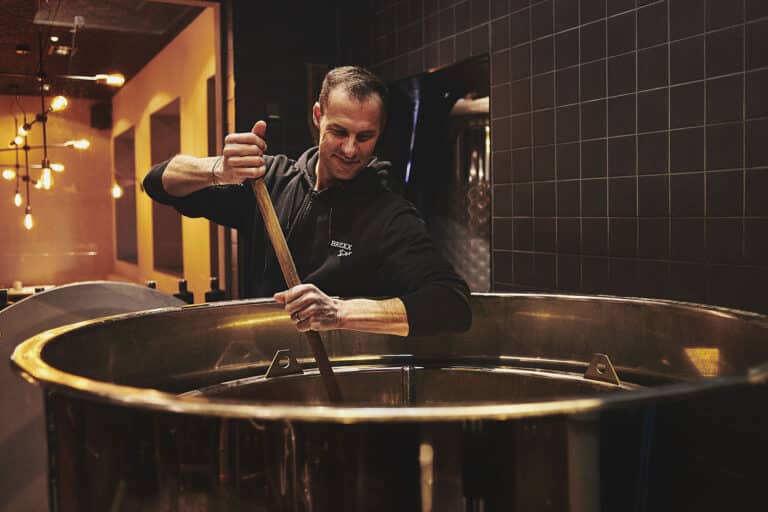 Bierbrauer rührt in Braukessel